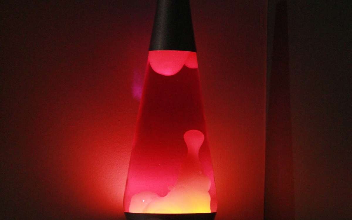 Photo of a lava lamp emiting red and yellow light in black background