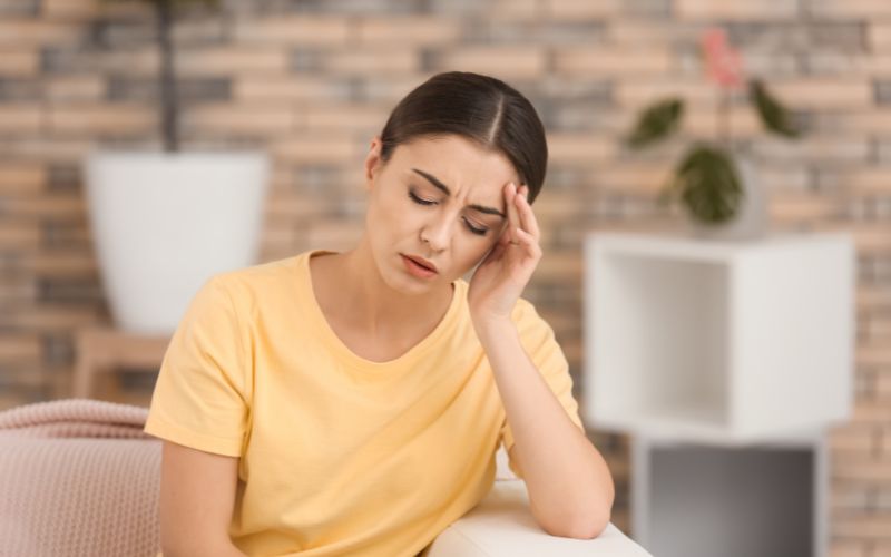 A woman in living room suffering headaches